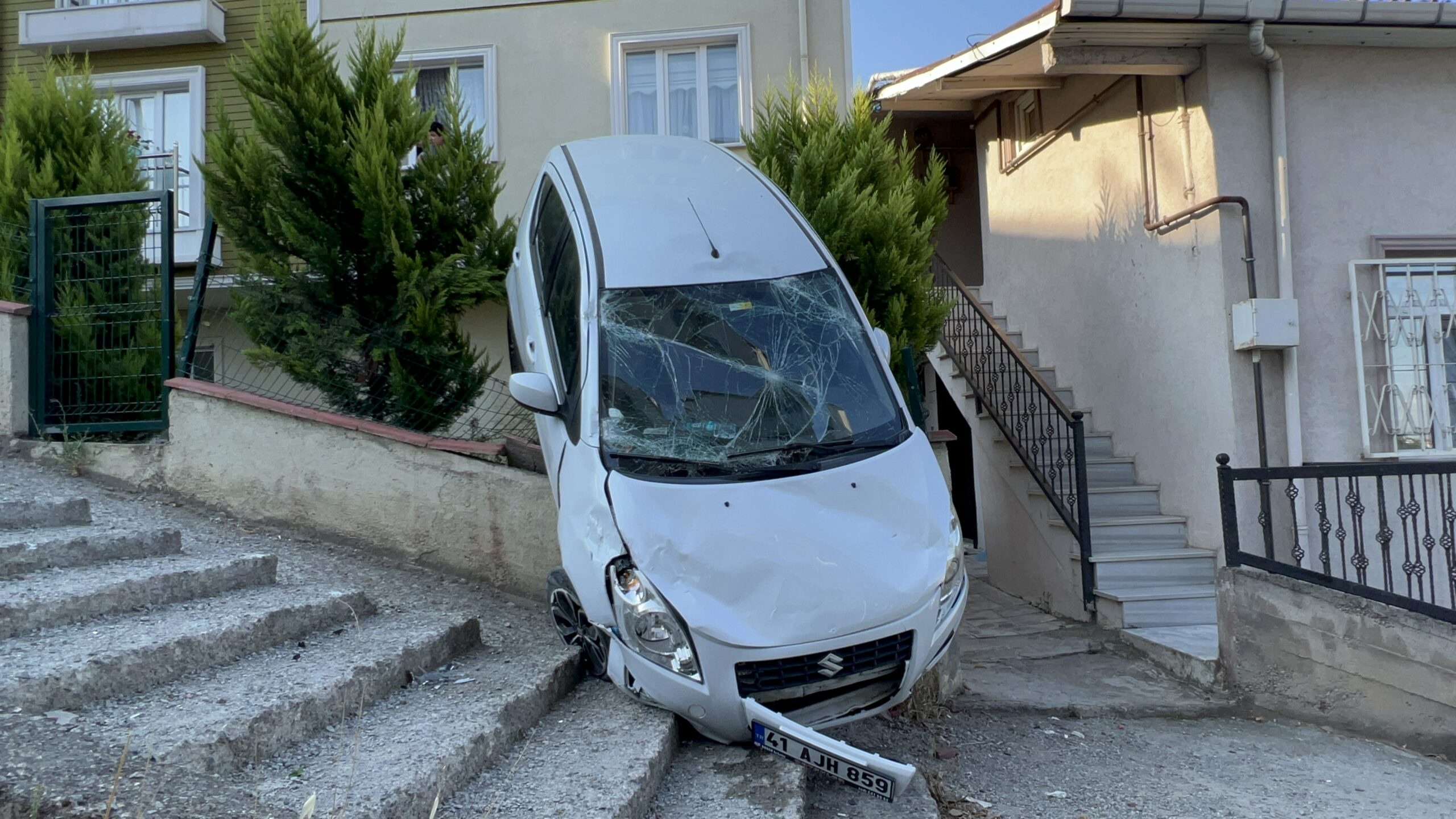 Kocaeli’nin Gebze ilçesinde bahçe duvarında asılı kalan otomobil, vinç yardımıyla bulunduğu yerden çıkarıldı.